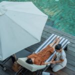 A relaxing spa treatment by the poolside in a luxury Bali resort during daytime.
