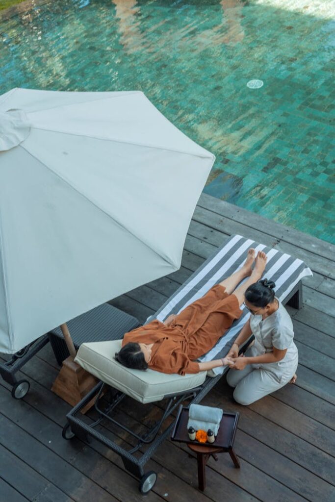 A relaxing spa treatment by the poolside in a luxury Bali resort during daytime.